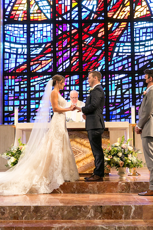 white floor altar pieces being bride and groom exchanging their wedding vows