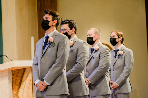 groomsmen with pale pink rose boutonnieres wearing protective face masks