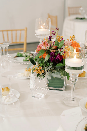 modern glass wedding tablescape with purple and orange flowers