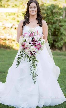 bride carrying a bouquet of white roses and stargazer lilies
