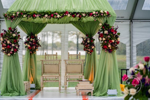 Philadelphia south Asian wedding ceremony with a soft mint green mandap with bold floral swags
