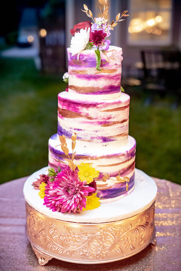 brightly colored modern wedding cake decorated with fresh flowers