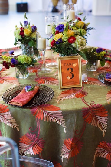 wedding reception table with embroidered linen, unique charger plates and elegant flowers