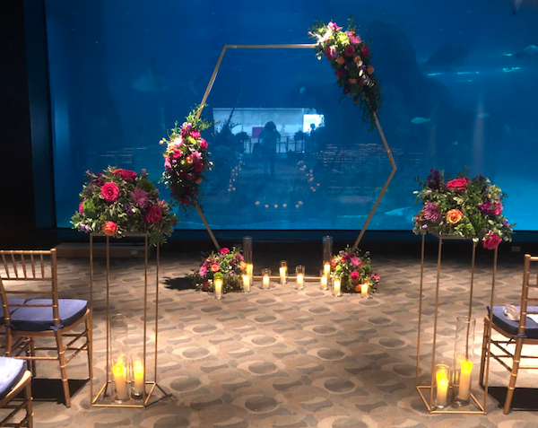 modern wedding ceremony structure with brightly colored flowers and pillar candles